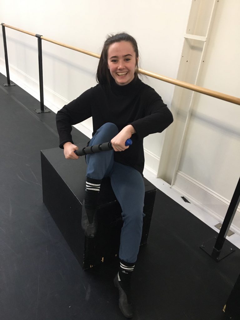 woman using roller massager on her leg